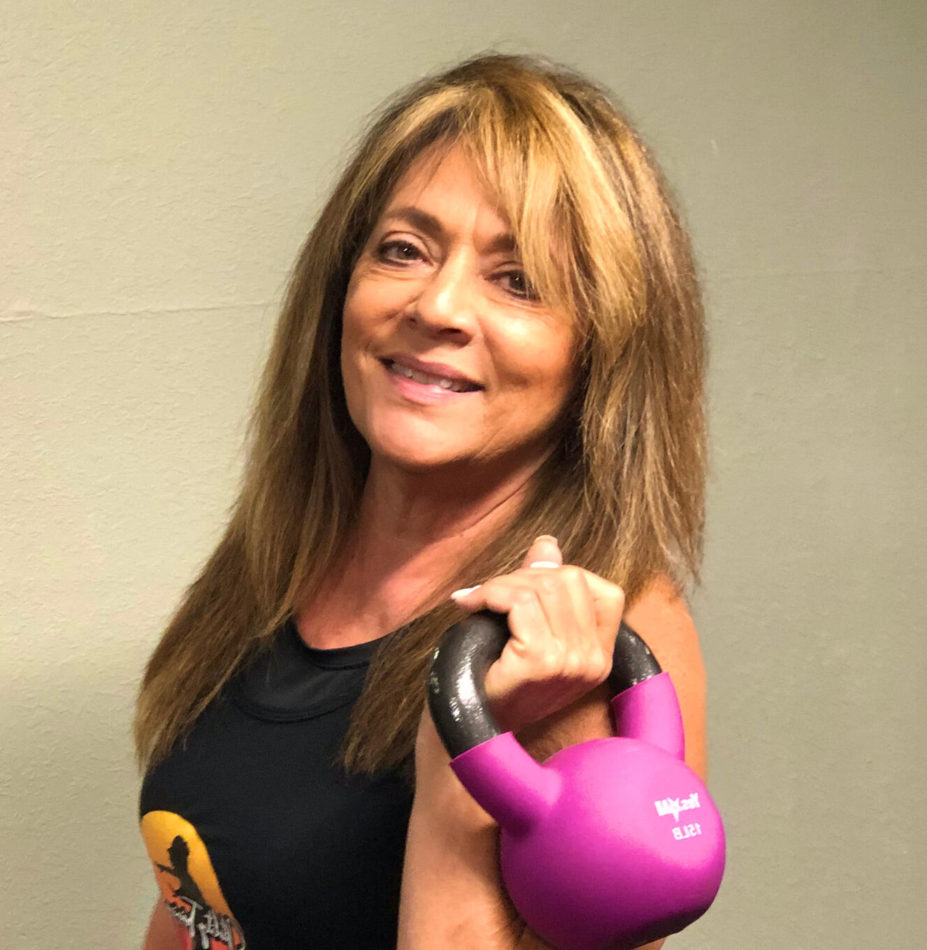 A woman fitness trainer holding a kettlebell